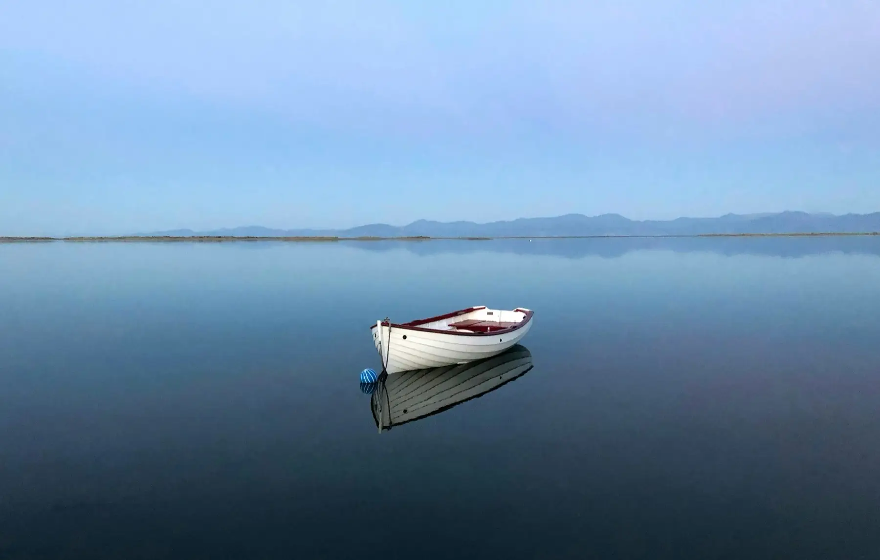 Small boat at dawn on calm water near Motueka, New Zealand